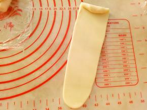 再依次用擀面杖擀成牛舌形（长度20CM左右）卷起来。