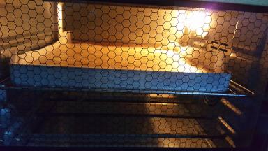 翻拌均匀，记得从底部充分翻拌，以免蛋黄糊残留在盆底。然后倒入铺了油纸的金盘中，刮板抹平表面，送入预热好的烤箱中层，上火130度下火110度25分钟左右。