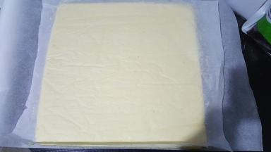 倒扣在铺了油纸的烤网上，底下的油纸揭掉，再盖在蛋糕体上，以免蛋糕干掉。