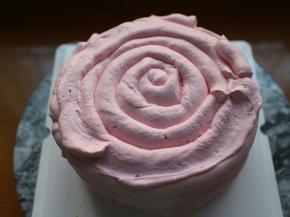 接着盖上最后一层蛋糕胚，将剩余的奶油装进裱花袋，挤在蛋糕周围及表面即可