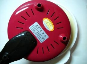 将饼铛翻转斜着贴近面糊，进而放平，让电饼铛薄薄的均匀沾满面糊。