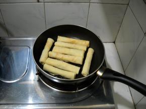 锅热抹一层薄油，放入卷好的春卷。
