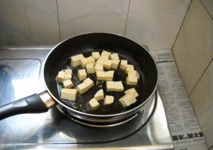 锅中油热，倒入豆腐煎制。