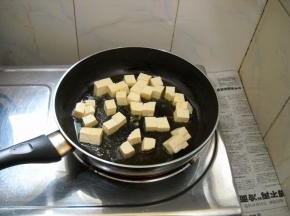 锅中油热，倒入豆腐煎制。