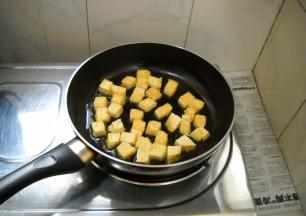 豆腐煎至两面酥黄。