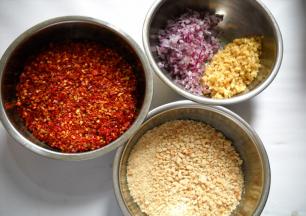 准备好食材。
干红椒用搅拌机打成粗粒；花生微波炉叮熟，去皮捣碎成粗粒；洋葱生姜洗净切细粒备用。