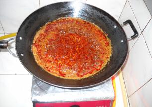 转小火慢慢熬制，锅中食油变成红色。