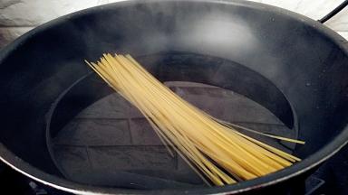 锅中注水，放入1茶匙盐，放入意面开启小火煮。