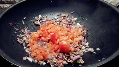 番茄切碎丁，放入锅中，盖上锅盖小火闷烧片刻。