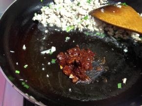 把肉馅拨到锅的一边，下入郫县豆瓣酱炒出红油