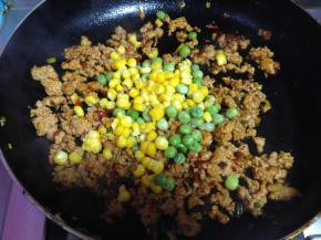加入豌豆粒和玉米粒和少量水炒约1分钟入味