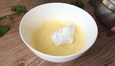 取三分之一蛋白加入蛋黄糊中，画圈翻版均匀