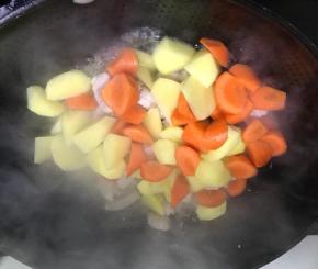 倒入土豆和红萝卜，翻炒后加水煮软
