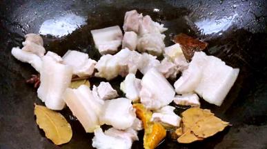 加入五花肉，煎炒至表面微黄