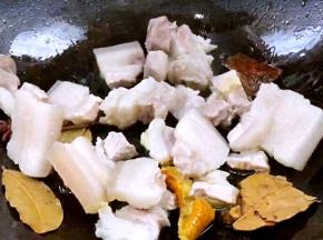 加入五花肉，煎炒至表面微黄