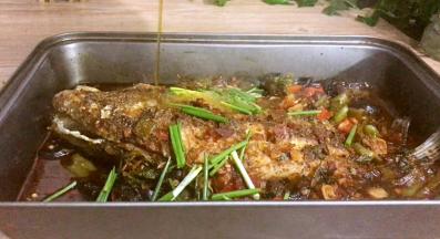 将烤箱里的鲫鱼拿出来，撒上葱段，再将刚做的麻辣油淋在葱段上即可