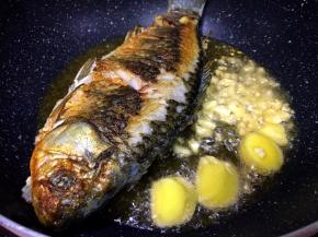 将鱼煎至两面金黄，将生姜蒜放入爆香