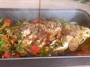 把刚做好的食材带汤倒入，装有鲫鱼的烤盘里，淋入蒸鱼豉油