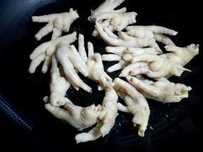 下入鸡爪翻炒均匀。