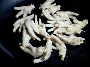 下入鸡爪翻炒均匀。