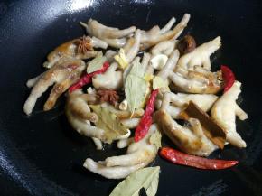 下入生姜、蒜瓣、八角、桂皮、草果、香叶、干辣椒、小米椒翻炒出香味。