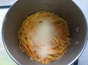 橙皮放到锅中，加入150克水和150克白糖烧开。