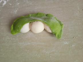 将绿色面皮包住白面团，并挰紧。