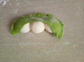 将绿色面皮包住白面团，并挰紧。