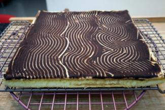 出炉后倒扣到网架上，撕去底部油纸然后盖上新油纸，冷却至温温的状态。