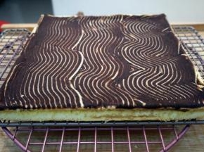 出炉后倒扣到网架上，撕去底部油纸然后盖上新油纸，冷却至温温的状态。