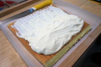 淡奶油250克加入25克细砂糖打发至硬性，然后装起约80克备用，剩余的都卷入蛋糕内。