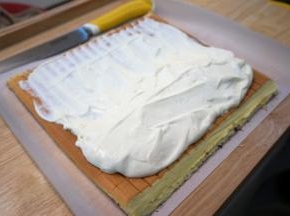 淡奶油250克加入25克细砂糖打发至硬性，然后装起约80克备用，剩余的都卷入蛋糕内。