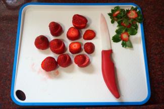 草莓洗净后去蒂，从顶部斜斜切开成大小两半。