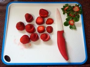 草莓洗净后去蒂，从顶部斜斜切开成大小两半。