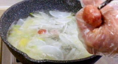 汤煮开后，用左手挤圆肉丸，用筷子夹入锅内，汤一直处于煮沸状态，挤入全部肉丸，再次煮开