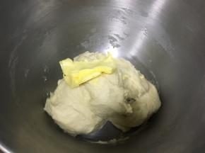 面团到扩展阶段（可以拉出厚膜，会破），加入软化的黄油，继续揉面