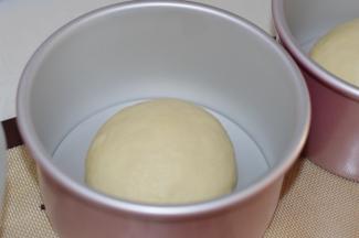 醒发好的面团，平分为两份，将其滚圆，放入两个6寸戚风模具中。我用的是学厨的加高戚风模具，做出来的面包长比较高。