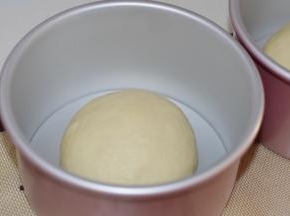 醒发好的面团，平分为两份，将其滚圆，放入两个6寸戚风模具中。我用的是学厨的加高戚风模具，做出来的面包长比较高。