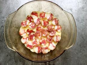 将土豆片平铺在碗底，在表面铺上一层香肠。