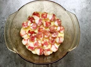 将土豆片平铺在碗底，在表面铺上一层香肠。