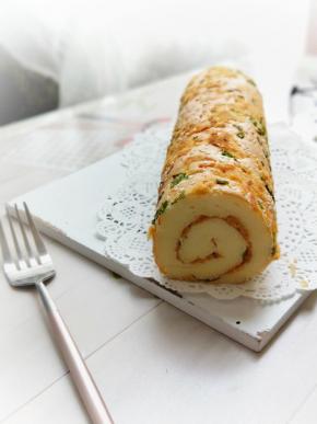 出炉后晾至温热不烫手就可以撕下油纸，，用蛋糕刀把对应的两边斜切，涂上一层沙拉酱，铺上肉松卷起来定型半小时