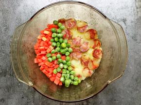 再在碗里铺上胡萝卜和豌豆。（喜欢吃得嫩，这一步不要放豌豆，这下一步放鸡蛋的时候放。因为豌豆是熟的，打久了会变干）