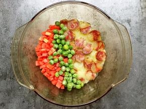 再在碗里铺上胡萝卜和豌豆。（喜欢吃得嫩，这一步不要放豌豆，这下一步放鸡蛋的时候放。因为豌豆是熟的，打久了会变干）