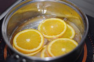 然后加入适量水和细砂糖，一同煮开，大约小火煮5分钟，让橙子汁充分溶于水中。因为后续需要用到汁水为60克，所以煮糖水的水不能少了。煮好的橙子片捞出放在晾网上沥干水分且放凉。