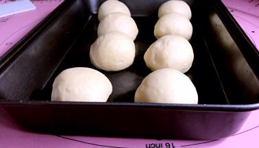 分成8份，团成小面团，放入不粘的烤盘里，再放入烤箱中层，发酵至两到三倍大