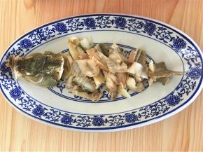煮熟的鱼头和鱼尾先摆入盘子两头，鱼骨摆中间，成鱼的样子。