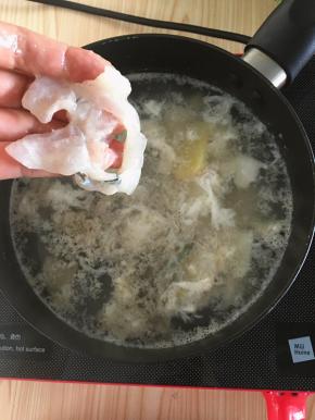 然后捞出锅里姜葱不要，再次把水烧开转小火，鱼片一片片的加入锅里煮熟。