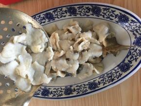 捞起鱼片铺在鱼骨上面。