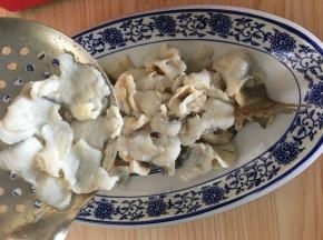 捞起鱼片铺在鱼骨上面。