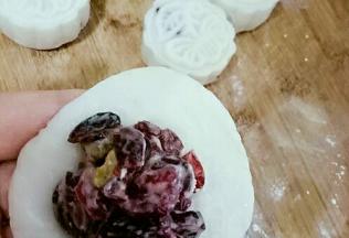 面团压扁，皮上放馅，包包子似的收口，团圆，放在放了熟糯米粉的案板上。